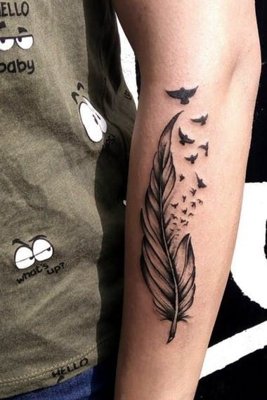 Tatouage plume avec des oiseaux qui s'envolent sur l'avant bras